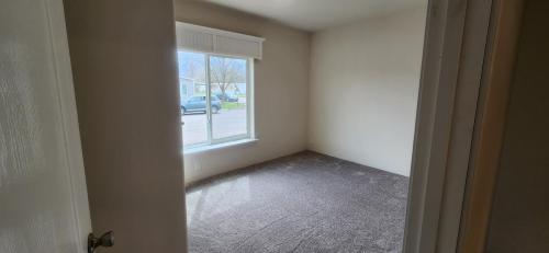 An empty room with a door leading to a window.