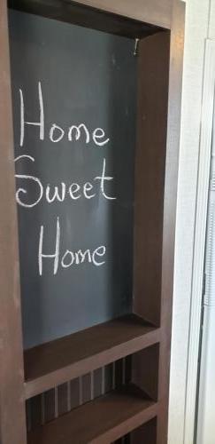 A shelf with a chalkboard saying home sweet home.