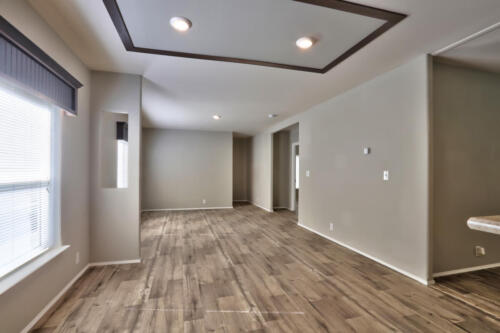An empty room with wood floors and white walls.