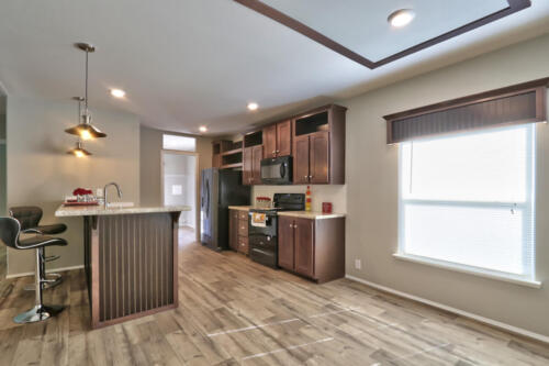 A kitchen with hardwood floors and a bar area.