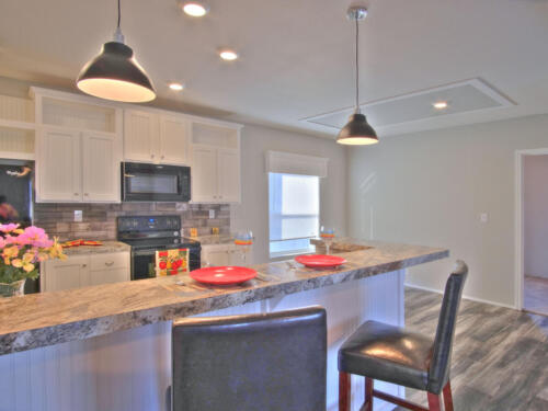 A kitchen with granite counter tops and stainless steel appliances.