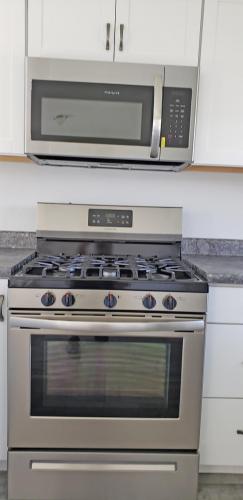 A kitchen with a stainless steel stove and microwave.